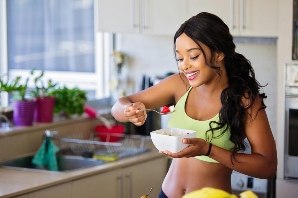 pexels-photo-1153372-1153372 Cheerful woman enjoying fresh strawberries in a cozy kitchen setting. Promotes healthy living and happiness.