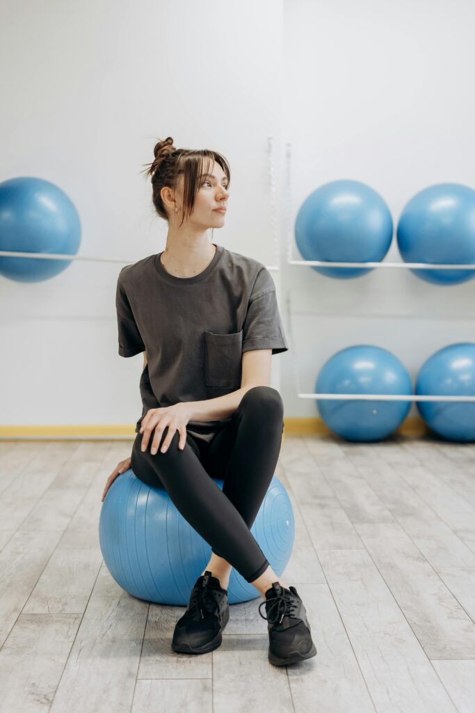 pexels-photo-6740746-6740746 A woman sitting on a yoga ball indoors, promoting a healthy and mindful lifestyle.